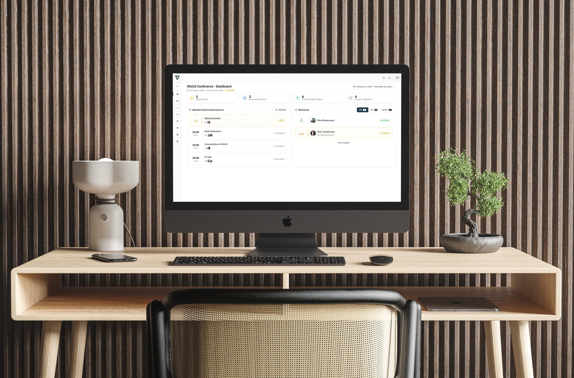 VAULO Events auf einem Bildschirm am Schreibtisch — das Konferenz-Dashboard mit Sessions, Zeiten und dem Status der Mitarbeiter