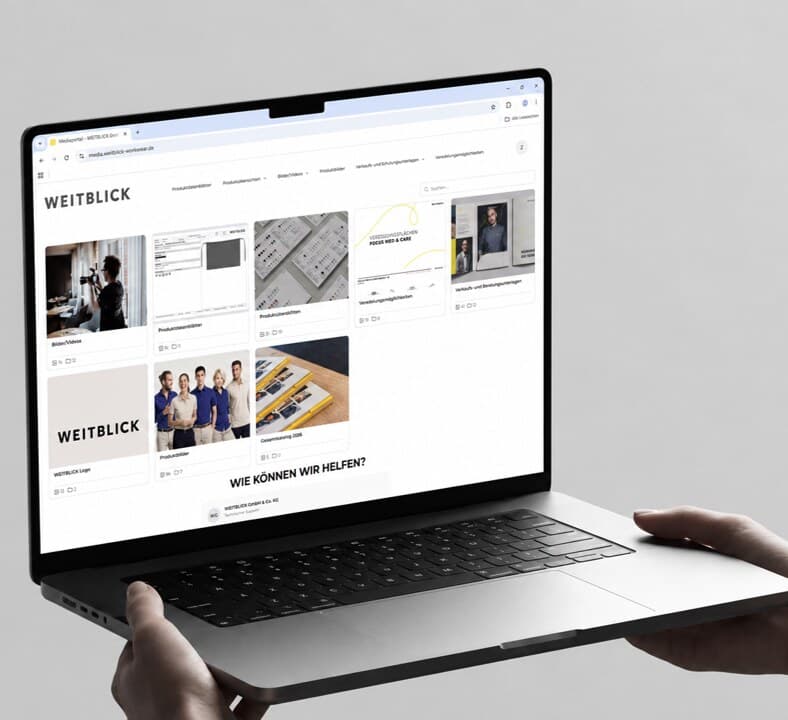 Das WEITBLICK-Medienportal auf einem Laptop — Kacheln mit Produktdatenblättern, Bildern und Verkaufsunterlagen unter dem WEITBLICK-Logo
