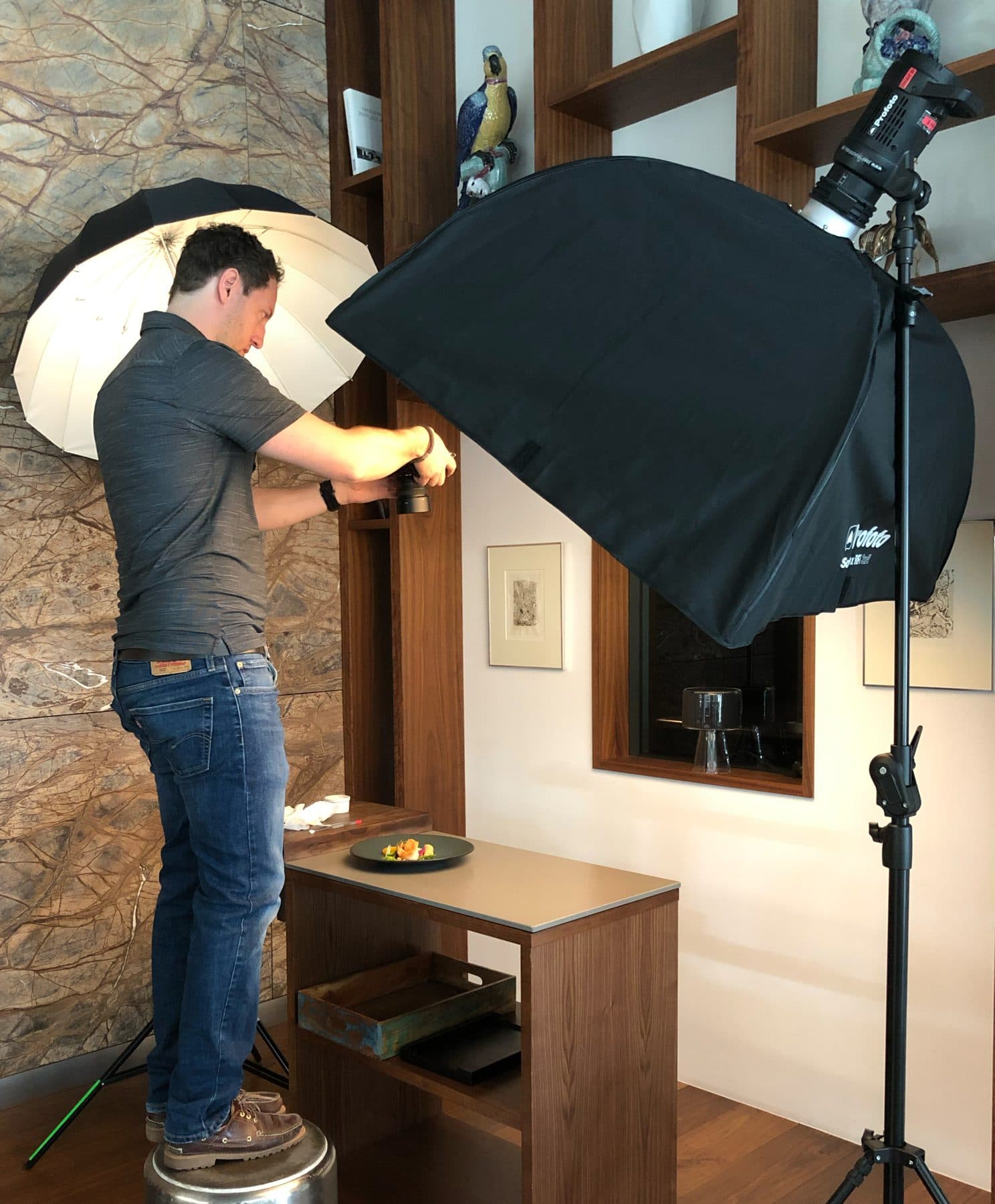 Marc Conzelmann beim Produktshooting — unter Schirm und Softbox richtet er ein angerichtetes Gericht auf dem Tisch ein; der Fotograf, aus dessen Alltag VAULO entstand
