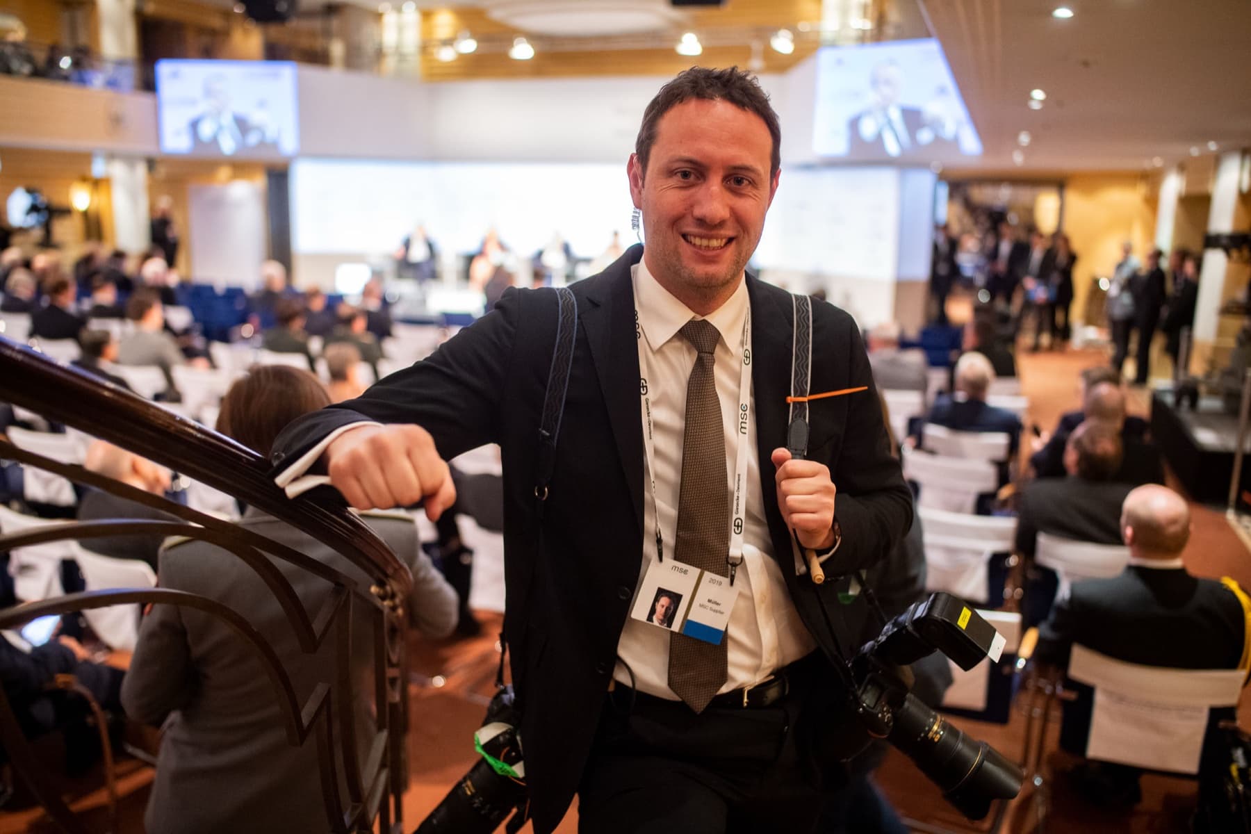 Marc Conzelmann mit zwei Kameras im Konferenzsaal der Münchner Sicherheitskonferenz — im Einsatz als Fotograf